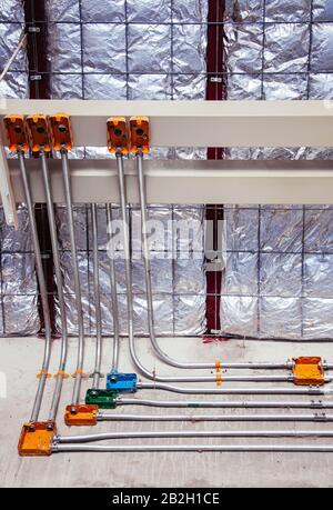 Elektrokasten und elektrische Drahtleitung an Betonwand an der Baustelle Stockfoto