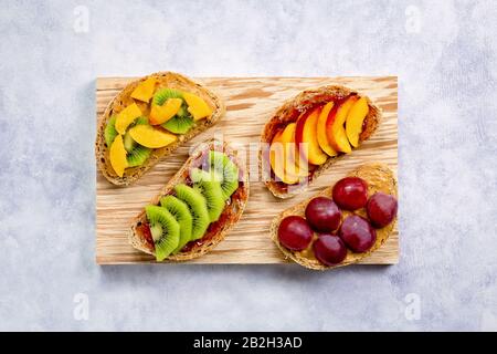 Gesundes Frühstück süße Toast mit verschiedenen Früchten und Beeren auf Holztisch. Kopierbereich, Draufsicht Stockfoto