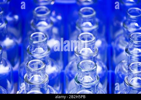 Blaue leere offene Glasflaschen mit Muster im Hintergrund Stockfoto