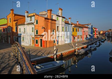 Burano, Venedig, farbenfrohe Häuser am Kanal im frühen Morgenlicht, Brücke, Boote, Anlegestellen an Corte Novello und Fondamenta della Pescheria Stockfoto