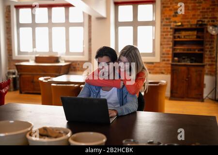 Junge Paare betrachten den Laptop zusammen Stockfoto