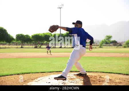 Baseballspieler, der während eines Spiels einen Ball wirft Stockfoto