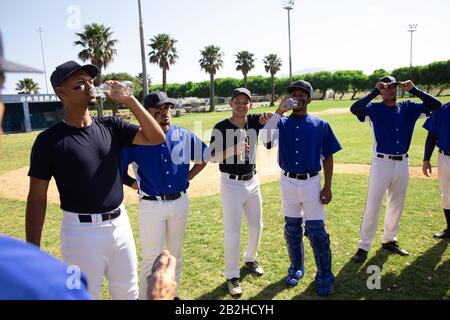 Baseballspieler trinken Wasser Stockfoto
