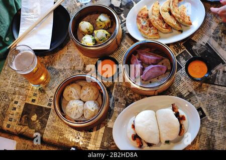 Asiatische Küche, Xiao Long Bao, Knistern Von Bauchschlägern Aus Schweinefleisch, Pfannkuchen, Chilisauce und Knödel, Sydney Stockfoto