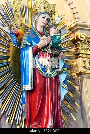 Manila, Philippinen: Detailansicht der farbenfrohen Statue von Mutter Maria mit Kleinkind Jesus, die sich in der berühmten Quiapo Kirche befindet Stockfoto