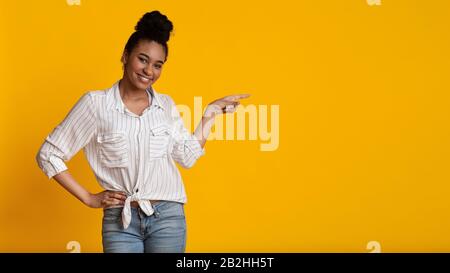 Fröhliche Afro-Frau In Legeren Kleidung, Die Auf Copy Space Zeigt Stockfoto