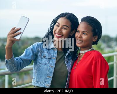 Zwei afroamerikanische Mädchen mit indigenen Merkmalen nehmen einen selfie zusammen Stockfoto