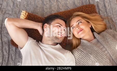 Schönes Paar auf Strickdecke liegend, Draufsicht Stockfoto