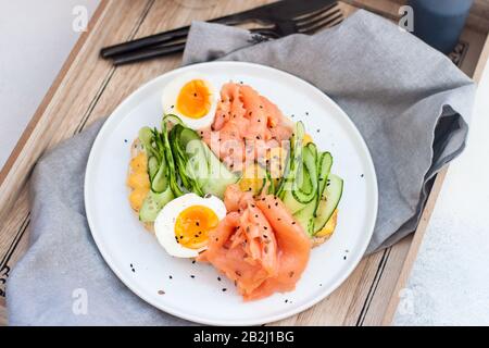 Räucherlachs, Frischkäse und Gurken-Toast-Sandwiches mit gekochtem Ei. Stockfoto