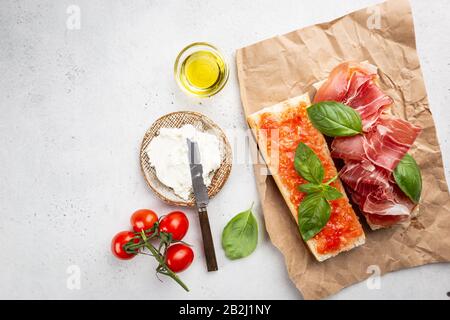 Spanisches Frühstück, Draufsicht. Toast oder Sandwich mit Jamon, Käse und Tomatensauce Stockfoto