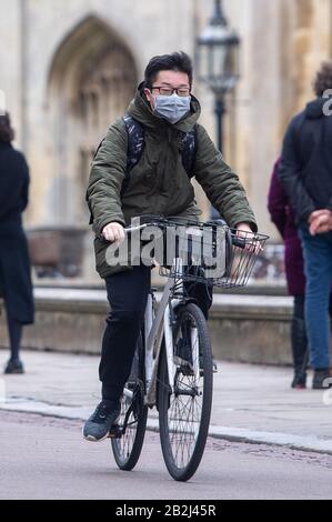 Ein Mann, der eine Gesichtsmaske trägt, geht am King's College in Cambridge vorbei, wie Premierminister Boris Johnson den Aktionsplan der Regierung für Coronavirus ankündigt. Stockfoto