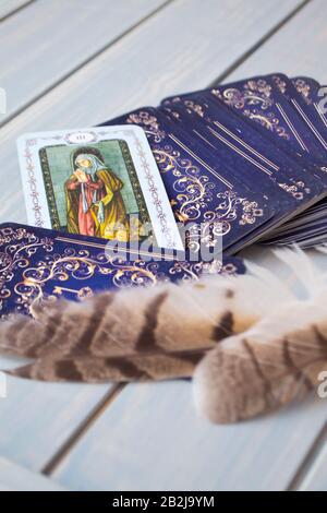 Esoterisches Stillleben mit Tarotkarte und Eulenfedern, vertikales Bild Stockfoto