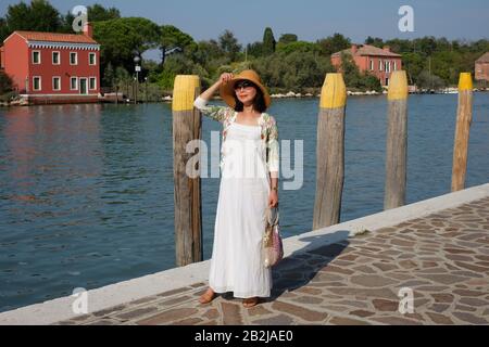 Weißes Kleid, La dolce vita, eine im Retro-Stil gehaltene Filmsternmode, die auf der venetianischen Insel Mazzorbo fotografiert wurde Stockfoto