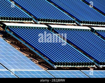 Kombination Dach Photovoltaik PV-Solarzellen und Solaranlage Rohrsystem auf Braun schrägen Ton Dach. sun Sammler Wasserleitung Heizelement Stockfoto