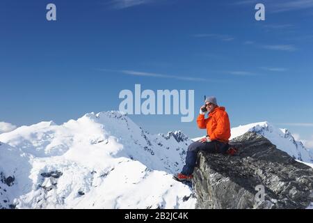 Bergsteiger mit Walkie-talkie auf Berggipfel Stockfoto