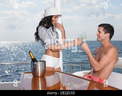 Junges Paar trinkt Champagner auf der Yacht Stockfoto