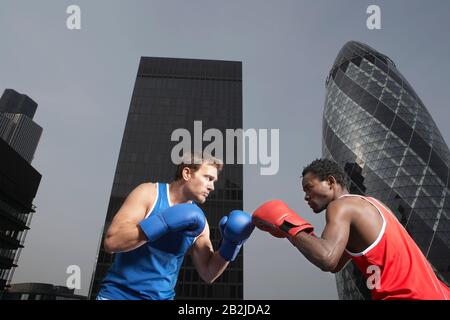 Zwei Boxer, die in den Innenstadtgebäuden mit niedrigem Blickwinkel in London England panzen Stockfoto