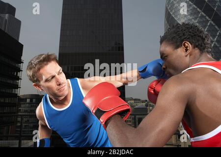 Zwei Boxer stanzen zwischen den Gebäuden in der Innenstadt von London England Stockfoto