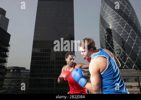 Zwei Boxer, die unter den Innenstadtgebäuden kämpfen, mit Blick auf London England Stockfoto