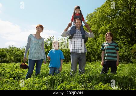 Eltern und Kinder (5-9) im Erdbeerfeldporträt Stockfoto
