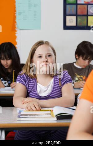 Mädchen (10-12) mit Down-Syndrom im Klassenzimmer Porträt Stockfoto