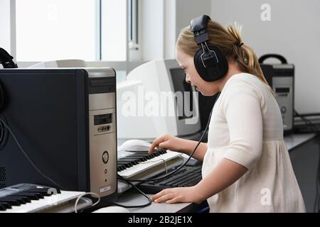 Mädchen (10-12) mit Down-Syndrom-Tonaufnahme im Heimstudio Stockfoto