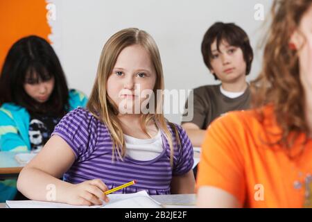 Portrait des Mädchens (10-12) mit Down-Syndrom im Klassenzimmer Stockfoto