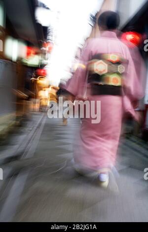 Japan Kyoto Pontocho-dori Frau trägt Kimono beim gehen auf engen Straßen Bewegungsunschärfe Stockfoto