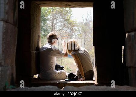 Ein Paar Sitzt im Fenster des Steingebäudes Stockfoto
