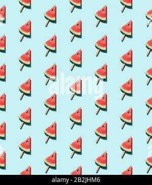 Nahtloses Muster für Wassermelonenpopsicle. Die Wassermelonenscheibe auf dem Holzpoppsikel klebt über blauem Hintergrund. Draufsicht oder flache Lage. Isometrische Ansicht Stockfoto