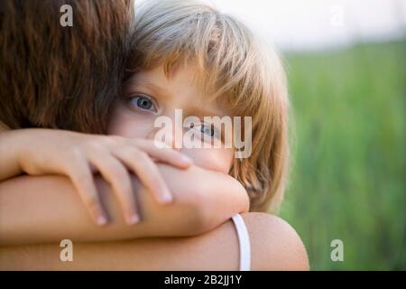 Kleines Mädchen umarmt ihre Mutter Stockfoto