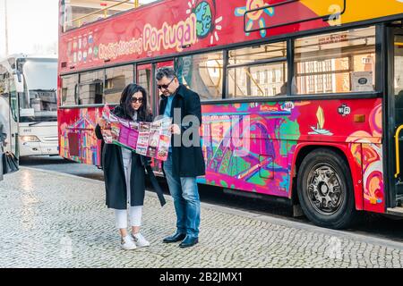 Ein Reisepaar, das die Karte vor dem Stadtblick auf den Bus in Lissabon Portugal Europe überprüft Stockfoto