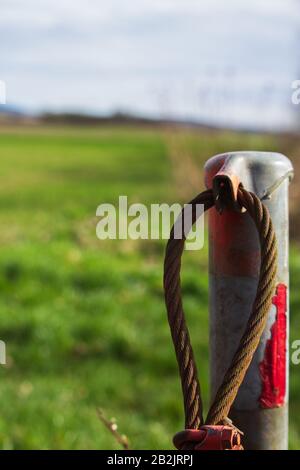 Verrosttes altes Stahlkabel einer ehemaligen, mit Moos bedeckten Barriere Stockfoto