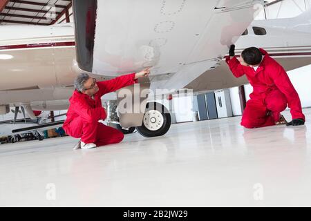 Flugmechaniker inspizieren Flugzeugflügel Stockfoto