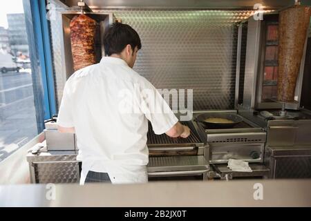 Mittlerer Erwachsener, der im Kebab-Shop arbeitet Stockfoto