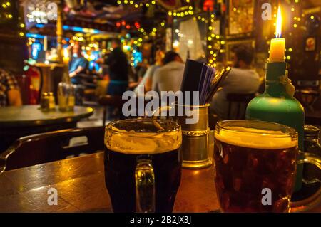 Ein paar Bierbecher in einem Edinburgh Pub, wobei der Hintergrund verschwommen ist Stockfoto