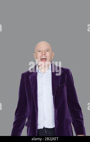 Porträt des schreienden Seniors über grauem Hintergrund Stockfoto