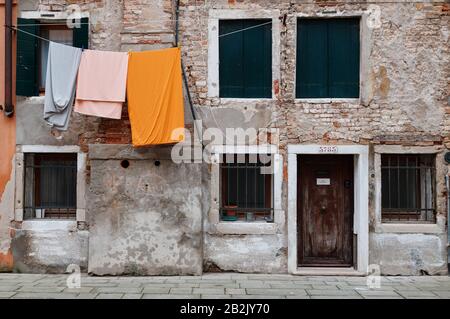 Wäscherei, die aus einer typisch venetianischen Fassade hängt. Italien. Stockfoto