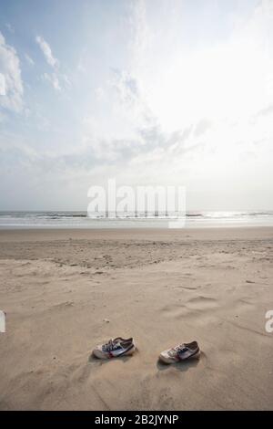 Leinwandschuhe liegen am Strand von Vagator, Goa, Indien Stockfoto