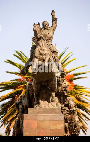 Eine bronzene Reiterstatue zeigt eine Militärfigur zu Pferd, die einen Arm in einer kommandierenden Geste hebt. Das Pferd zieht sich auf, und der Reiter trägt historische Militärkleidung. Die Basis von Stockfoto