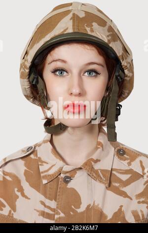Porträt der jungen Frau in Militäruniform vor grauem Hintergrund Stockfoto