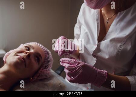 Gesunde, schöne Haut. Kosmetikerin macht Masken junges schönes Mädchen, Spa-Salon Stockfoto