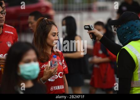 Die Gesundheitsmitarbeiter, die die Temperaturen von Muangthong united Fans während des thailändischen Ligaspiels zwischen Muangthong united und Chonburi im SCG-Stadion als Schutzmaßnahme gegen Corona-Virus überprüfen.die Fälle von Corona-Viren in Thailand erreichten am 03. März den 43. Der erste Corona-Virustod war am 01. März. Stockfoto