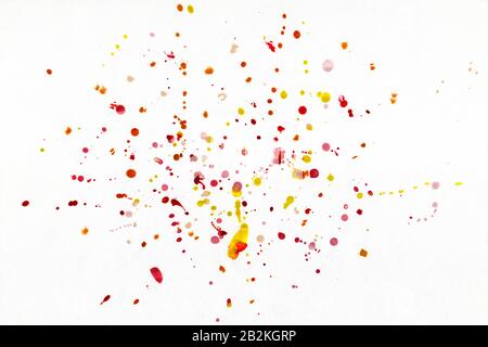 Rote und gelbe Tropfen in Form von Wasserfarben-Spray auf weißem Hintergrund. Stockfoto