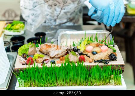 Der Koch im Restaurant bereitet ein Gericht zu, er beendet das Gericht auf einem Teller Stockfoto