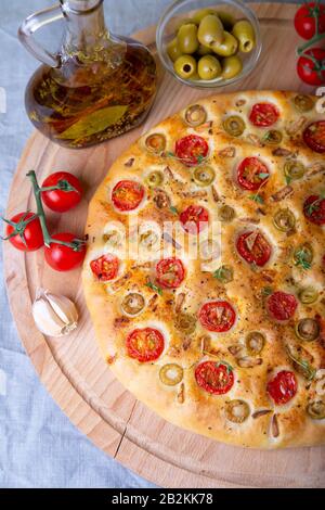 Focaccia mit Tomaten und Oliven. Traditionelles italienisches Brot. Hausgemachtes Backen. Nahaufnahme, selektiver Fokus. Stockfoto
