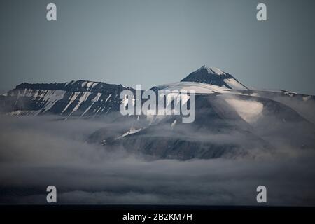 Mystische Wolken spiegeln sich im arktischen Wasser in Spitzbergen wider Stockfoto