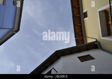 Spanisches Buch deckt Vielfalt/Wände von Stadthäusern ab, die sich auf Höhe der Decke verbinden und einen blauen Himmel zeigen und das Gefühl der Fülle erzeugen. Stockfoto