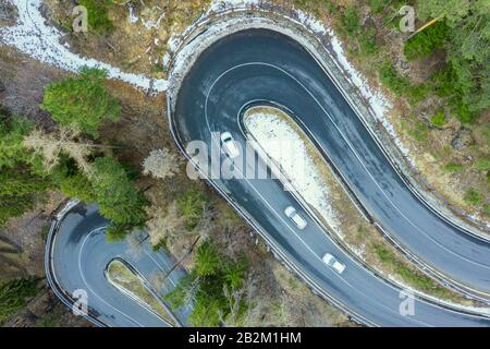 Luftbild einer Autoserpentin auf einem Berg. Straße zum Dorf La Thuile und Skigebiet. Bergserpentin im Aosta-Tal in Italien. Stockfoto