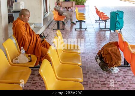 PHOTHARAM, THAILAND, Jun 02 2018, buddhistischer Mönch auf dem Bahnsteig sitzend und auf den Zug wartend Stockfoto